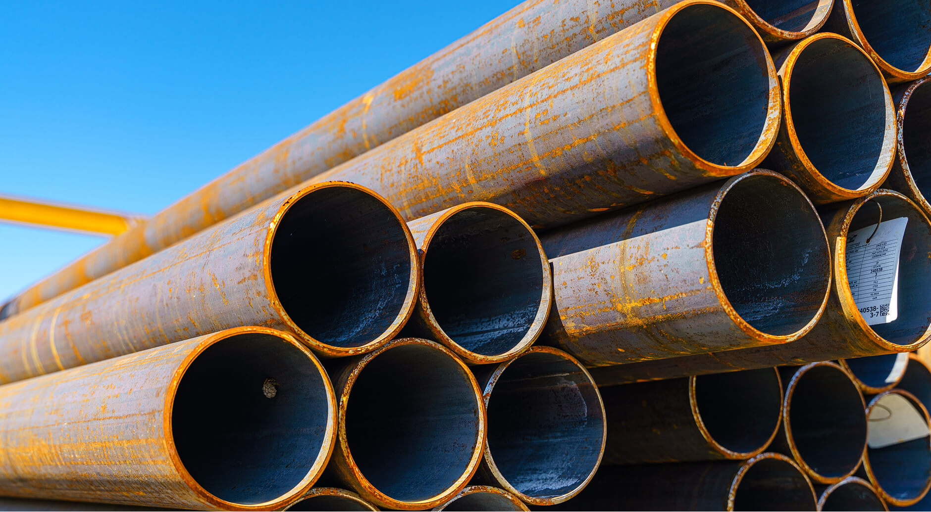Stacked carbon steel A106 pipe in various diameters showing Saginaw Pipe's inventory stocking depth